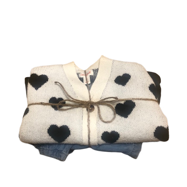 Folded blanket with black polka dots on a wooden surface