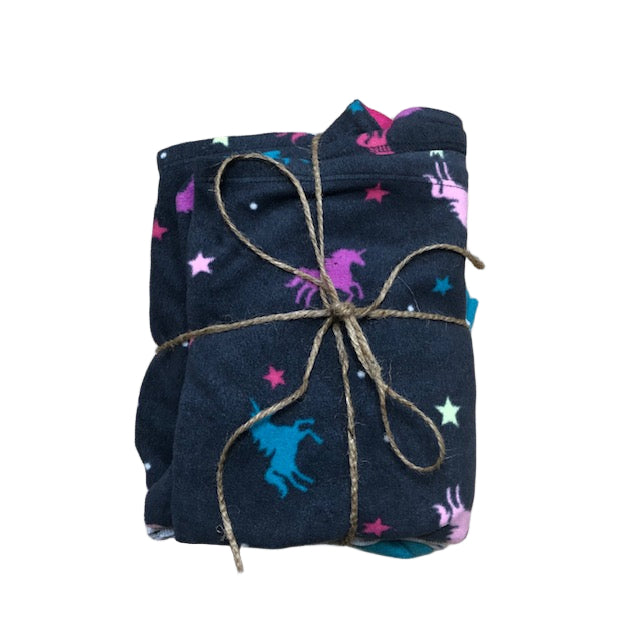 Folded dark blue fabric with colorful patterns tied with twine on a wooden surface